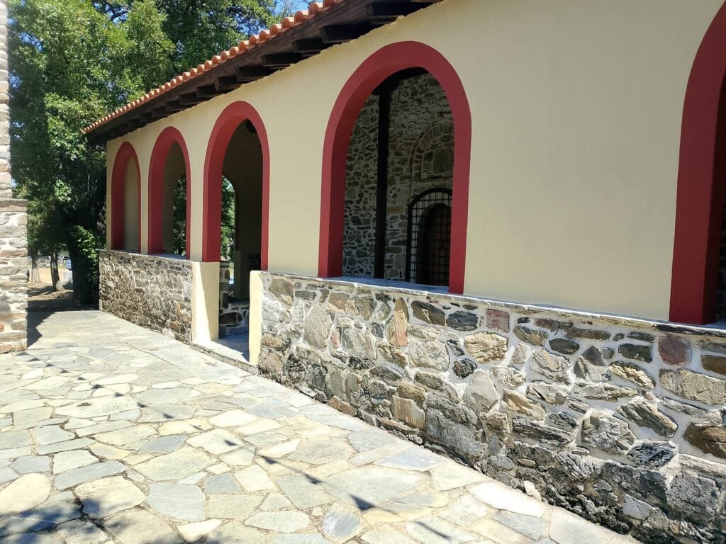 Traditional stone building in Parthenon, Halkidiki, with cream walls and red-trimmed arched openings