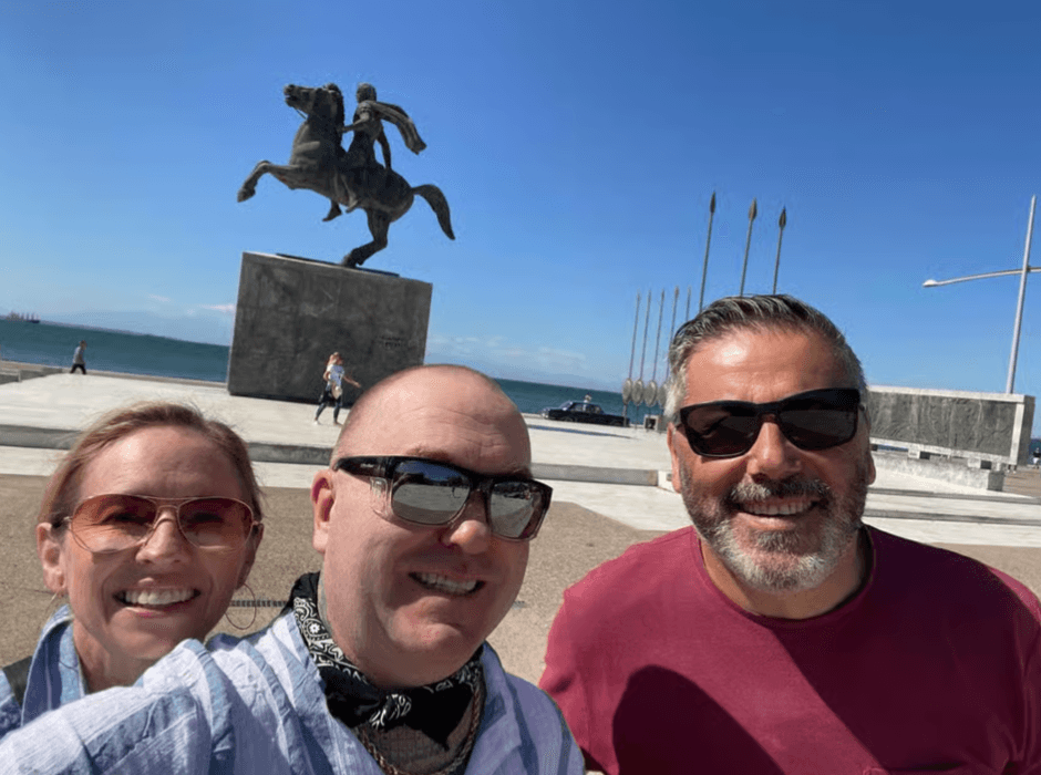 Travelers smiling in front of the Alexander the Great statue on the Thessaloniki waterfront