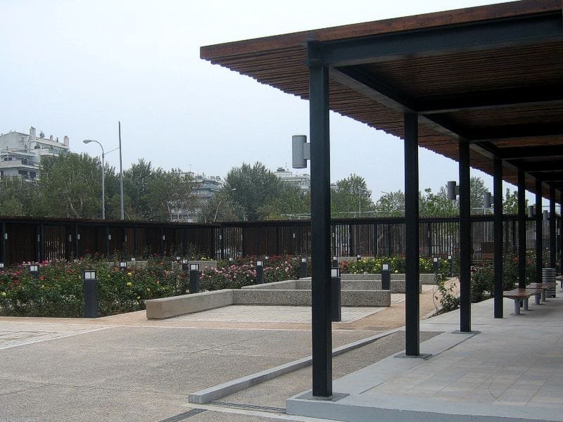 Perimeter pergola and flower beds with colorful roses and concrete seating in the Rose Garden