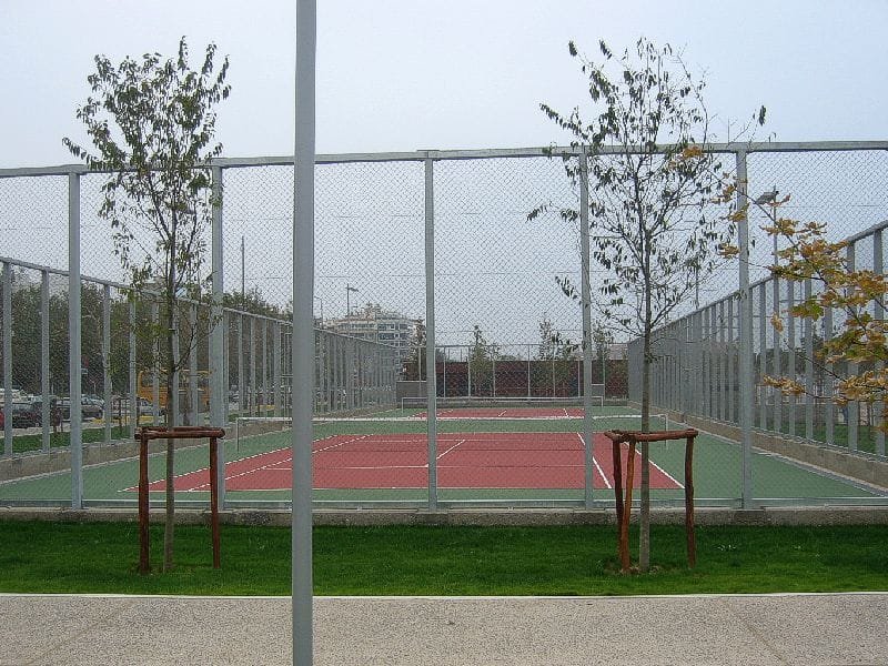 Fenced tennis courts with red and green surfaces in the Garden of Remembrance